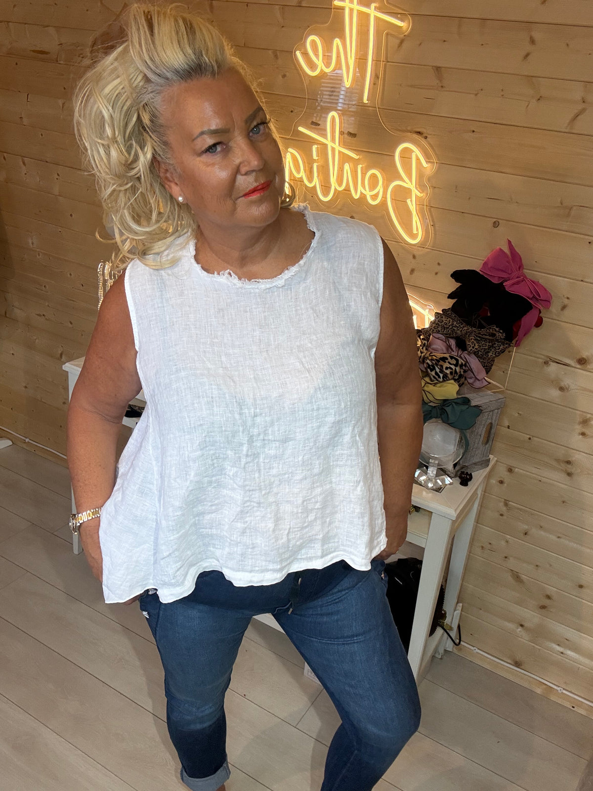 Drift white textured sleeveless top front view close up showing frayed neckline and basket weave fabric with navy jeans