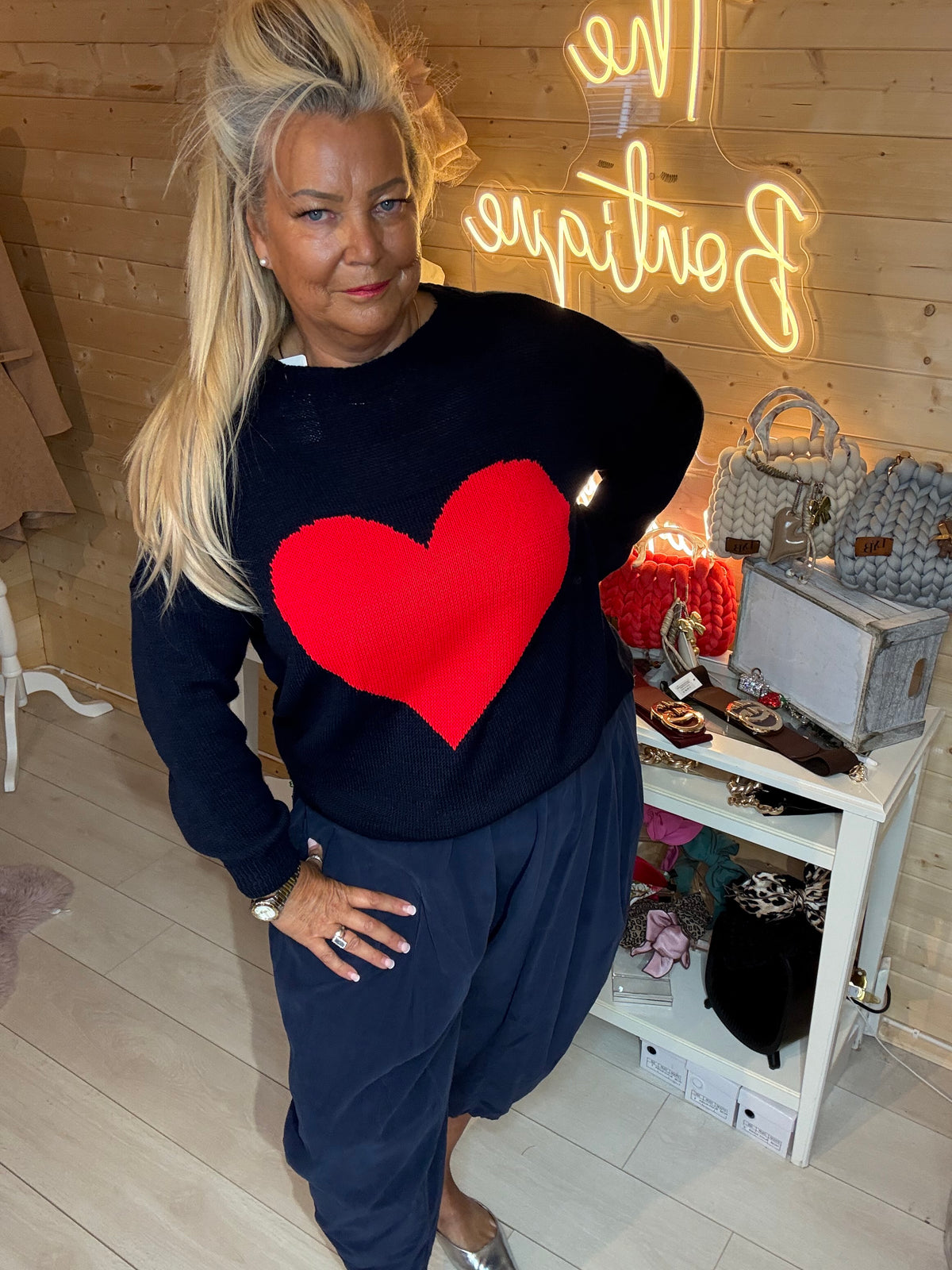 Close-up of the navy knit jumper showing its large red heart motif and long sleeve
