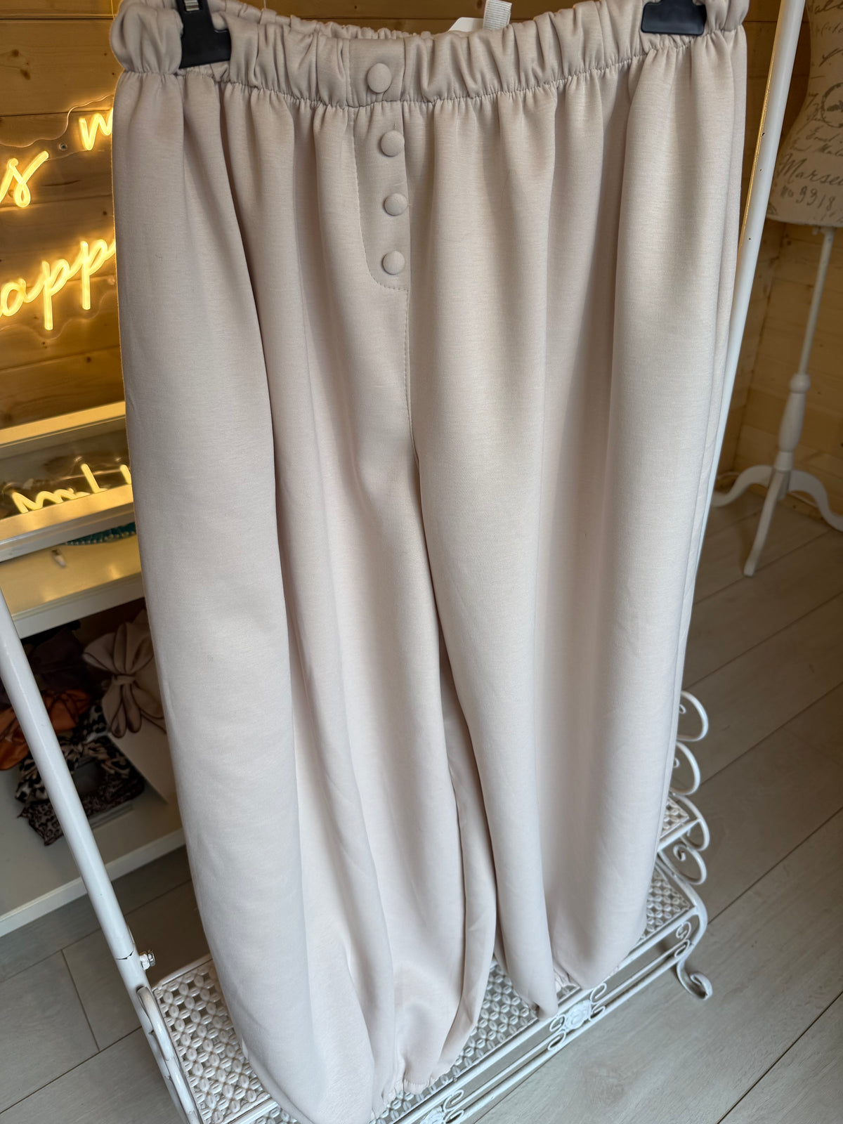 Lodi Cream balloon trousers on a hanger showing front button detail and gathered hems