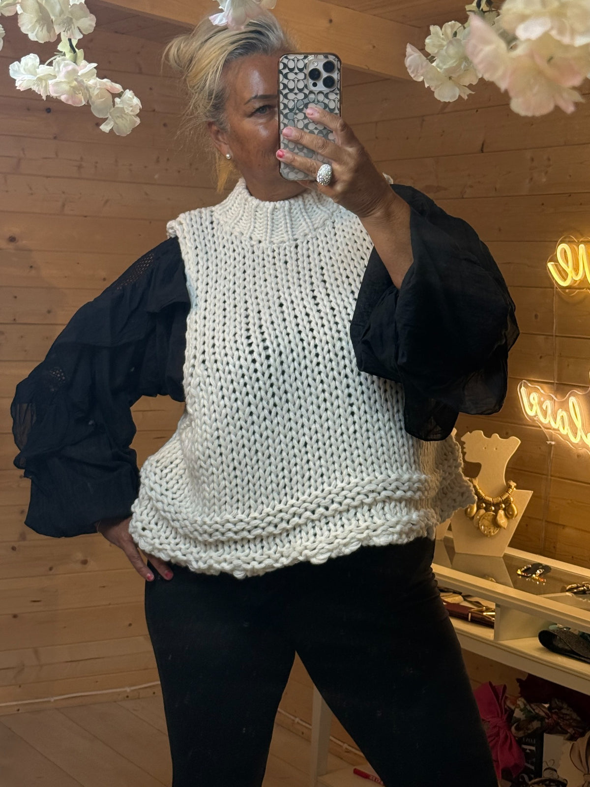 Mabel cream chunky knitted tank top layered over black blouse with statement sleeves