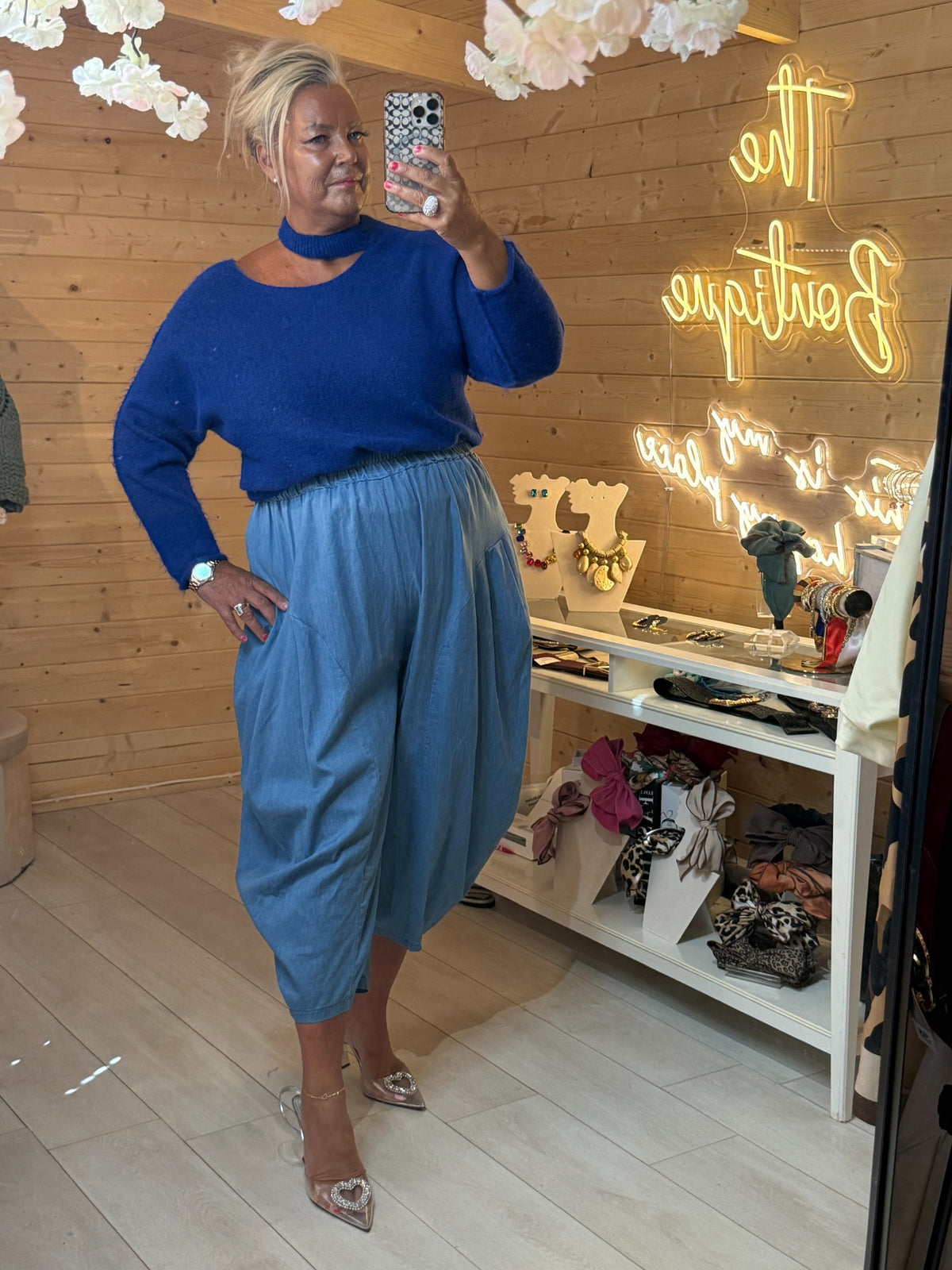 Mira electric blue soft knit jumper with cut-out choker neckline, worn with blue trousers