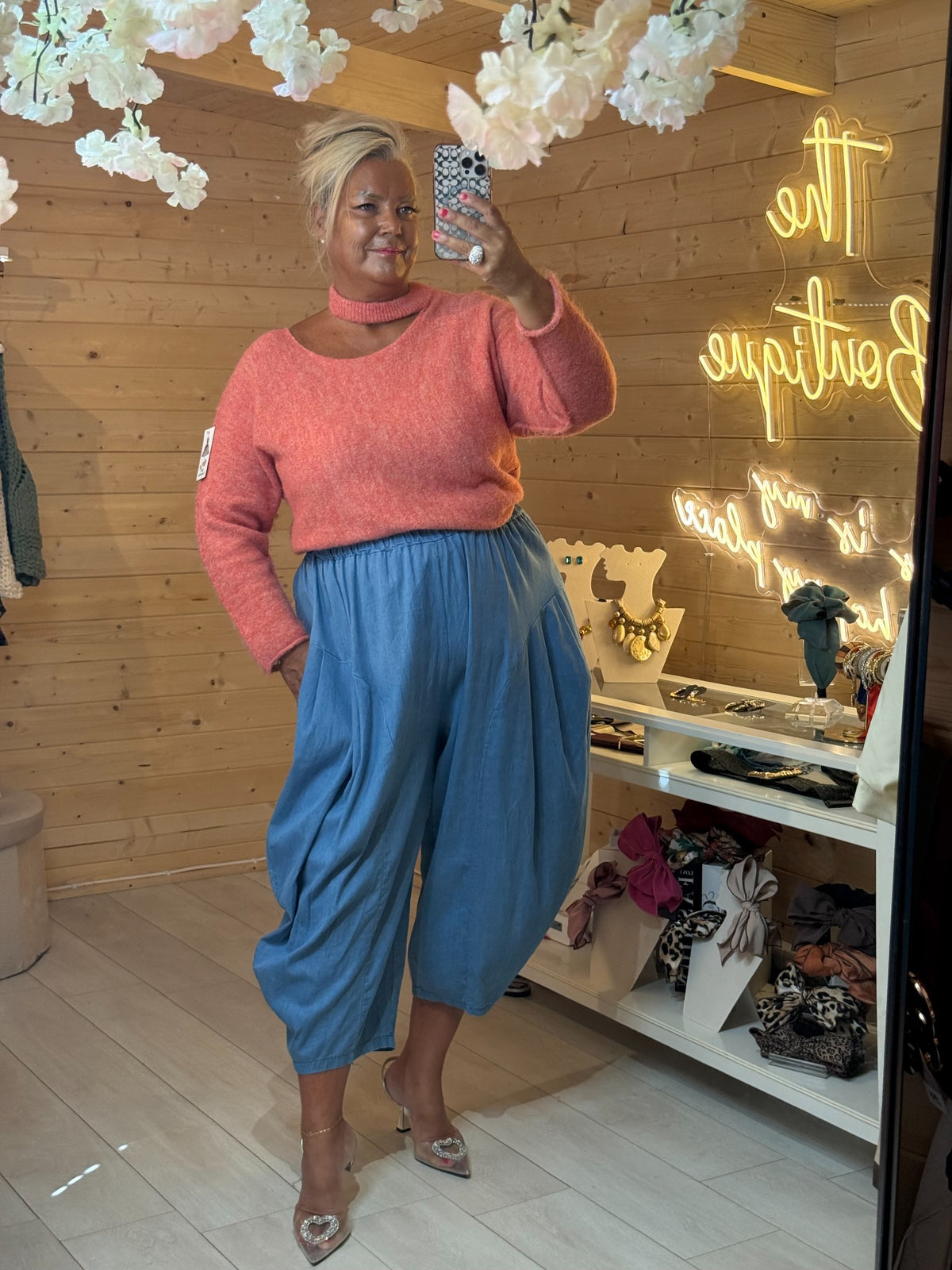 Mira salmon pink soft knit jumper with cut-out neckline, worn with light blue trousers