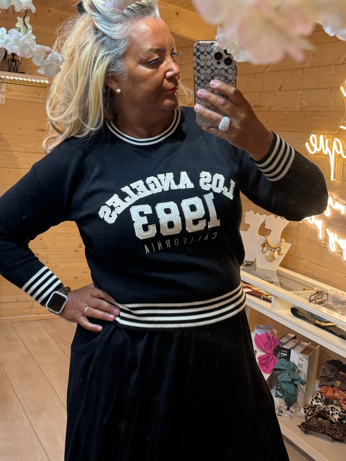 Close-up of black Monroe jumper showing lettering and striped rib trims