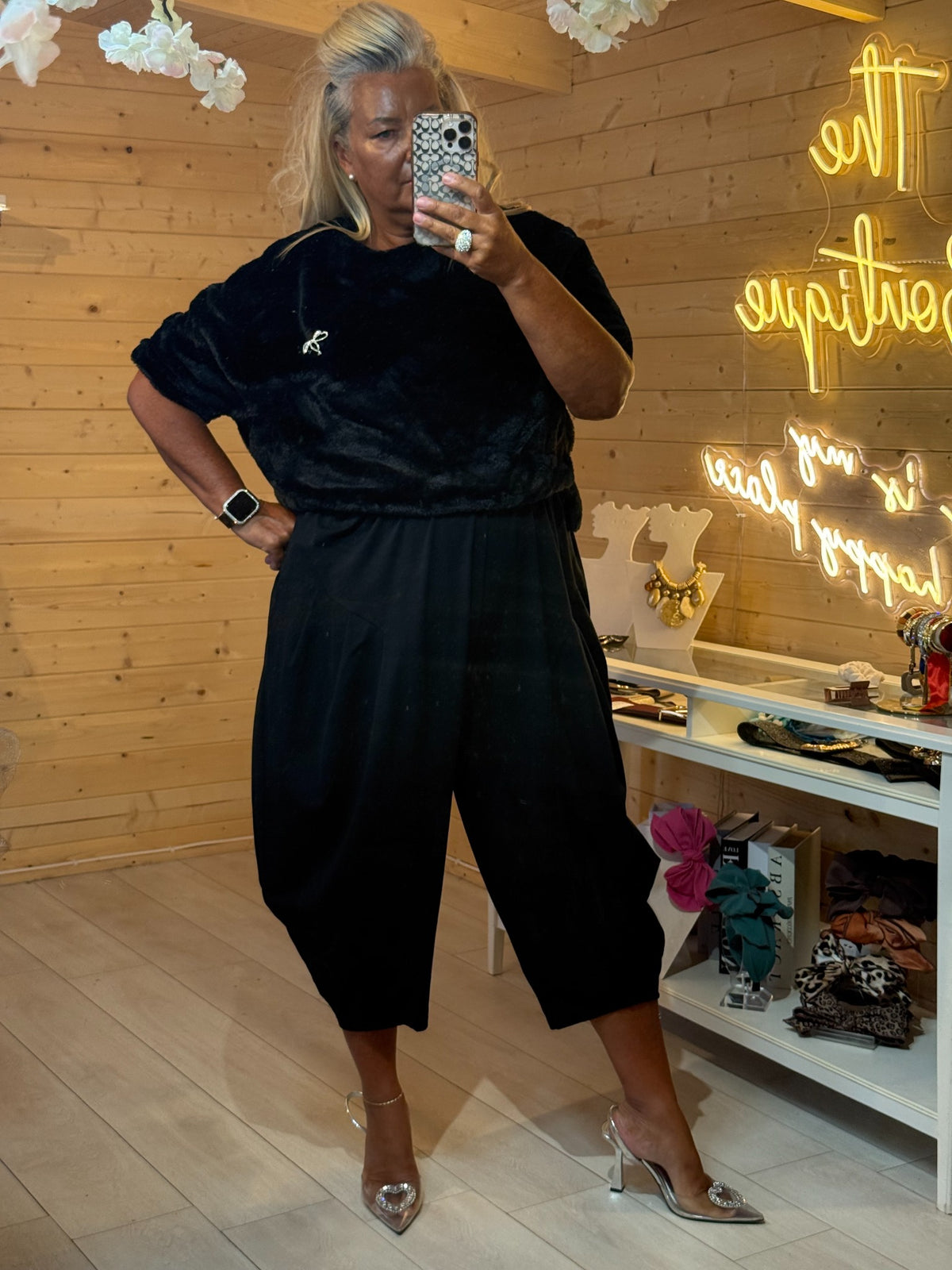 Orla black faux fur jumper with diamanté bow brooch styled with black slouch trousers